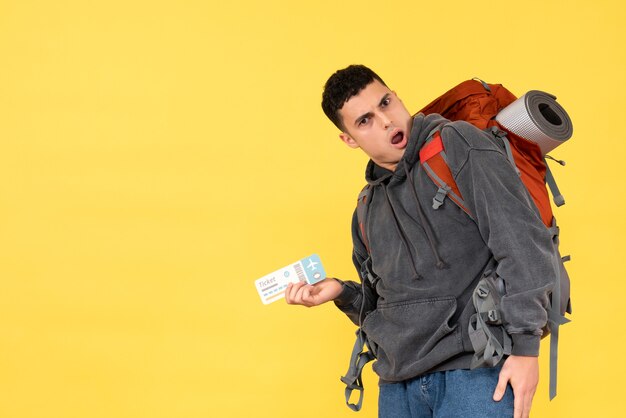 Vorderansicht erstaunter reisender Mann mit rotem Rucksack, der Ticket hält