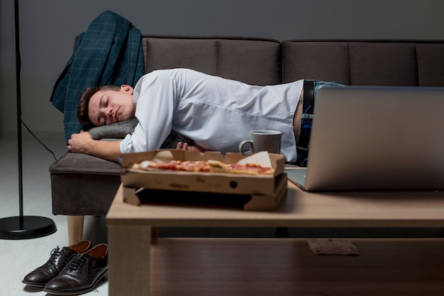 Kostenloses Foto vorderansicht erwachsener mann, der auf der couch schläft