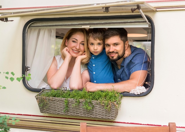 Vorderansicht Familie, die aus dem Fenster eines Wohnwagens schaut