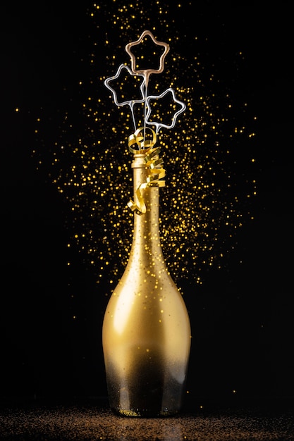 Kostenloses Foto vorderansicht festliches neujahrs-arrangement mit goldener flasche