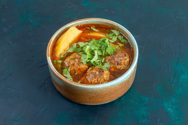 Kostenloses Foto vorderansicht fleischsuppe mit fleischbällchengrün und geschnittenen kartoffeln auf dem dunkelblauen schreibtischnahrungsmittelsuppen-gemüsegericht