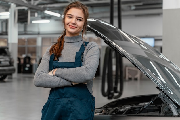 Kostenloses Foto vorderansicht frau, die an einem autoservice arbeitet