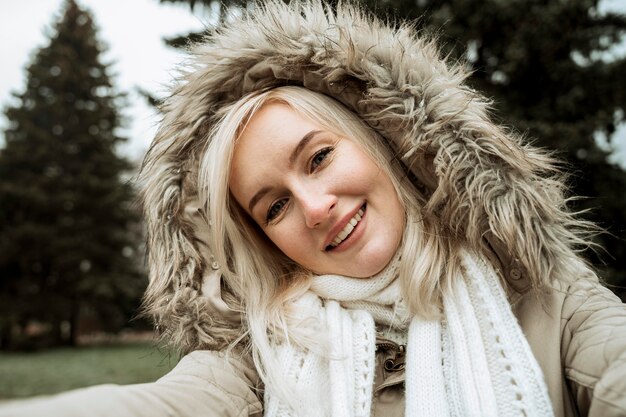 Vorderansicht Frau, die ein Selbstfoto im Winter macht