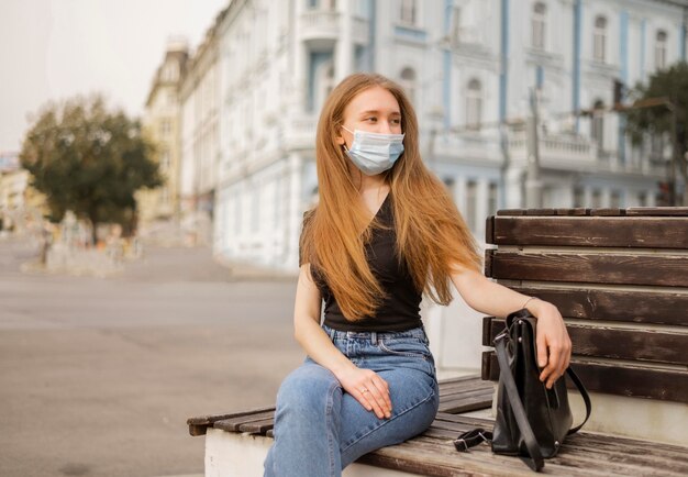 Vorderansicht Frau, die eine medizinische Maske draußen trägt