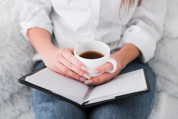 Vorderansicht Frau, die eine Tasse Kaffee hält