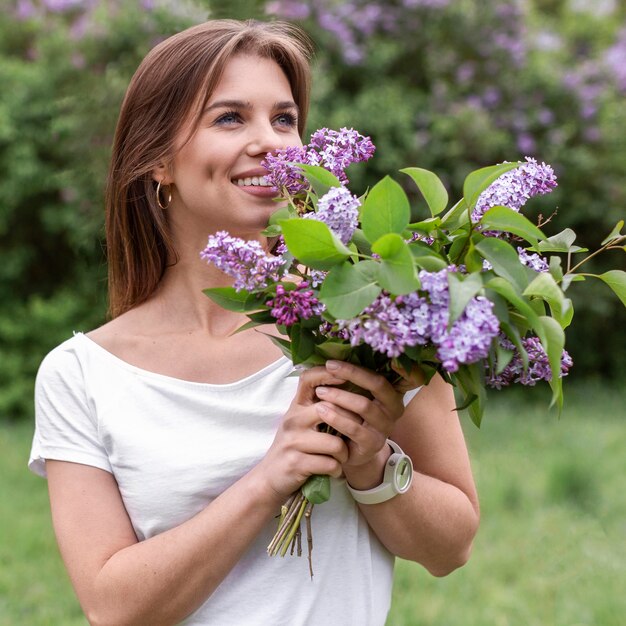 Vorderansicht Frau, die lila Blumenstrauß riecht