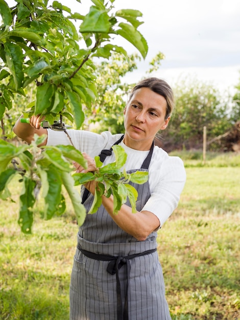 Vorderansicht frau, die sich um einen baum kümmert