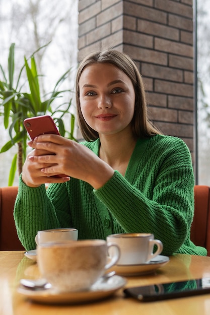 Kostenloses Foto vorderansicht frau, die smartphone hält