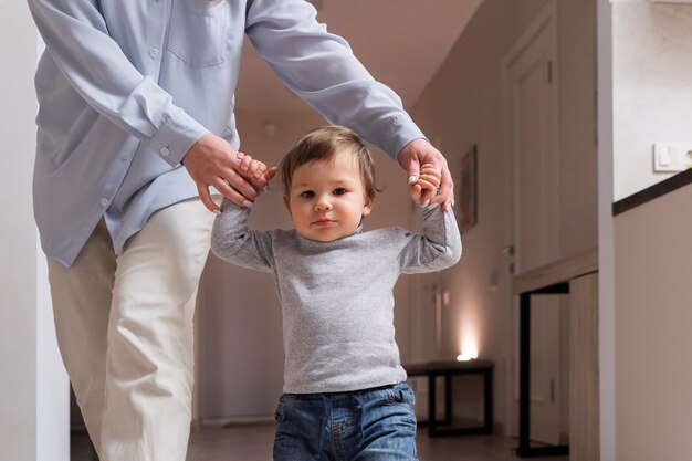 Vorderansicht Frau, die zu Hause Kinderhände hält