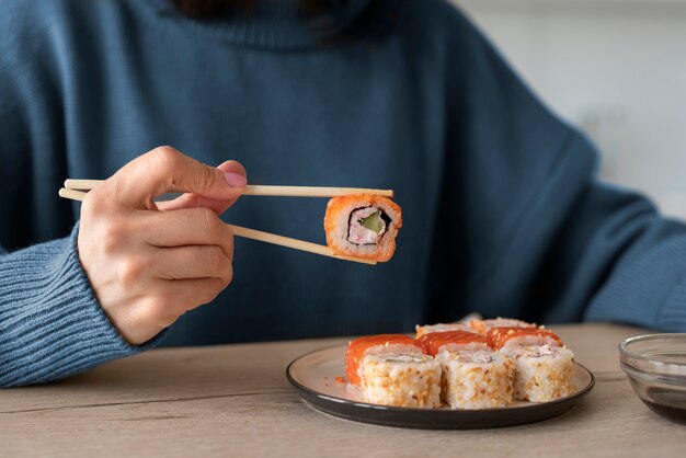 Vorderansicht Frau, die zu Hause Sushi isst