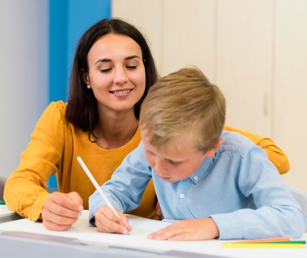 Vorderansicht Frau hilft ihrem Schüler in der Klasse