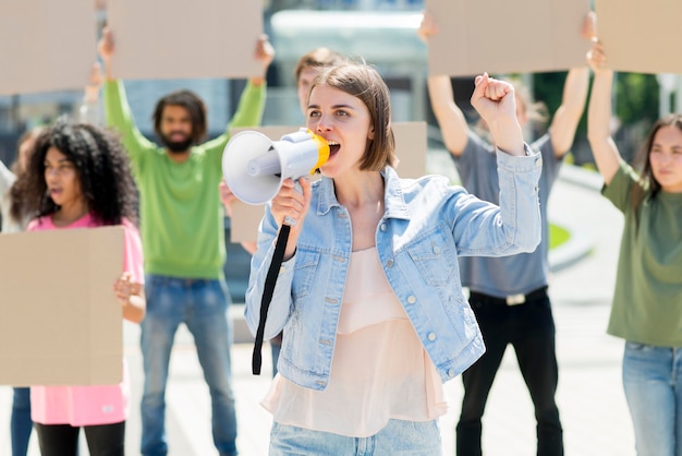 Vorderansicht Frau mit Megaphon, das in der Straße protestiert