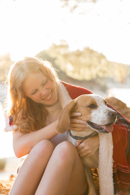 Vorderansicht Frau und Hund in eine Decke gewickelt