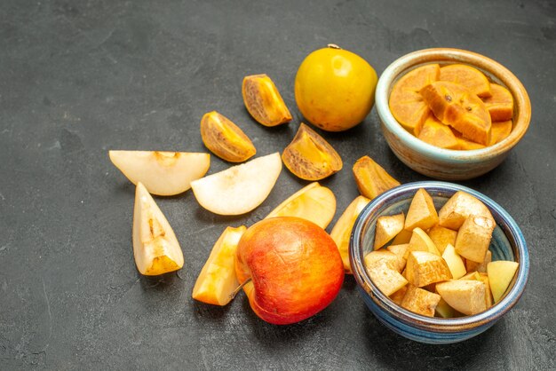 Vorderansicht frisch geschnittene Früchte Äpfel und Kakis auf dunklem Tischfrucht frischem Baum
