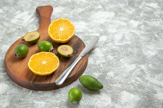 Vorderansicht frisch geschnittene Orangen mit Feijoa auf weißem Hintergrund reife Frucht exotische tropische frische