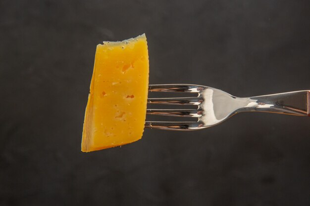 Vorderansicht frisch geschnittener Käse auf Gabel dunkle Snackmahlzeit Farbfoto knackig