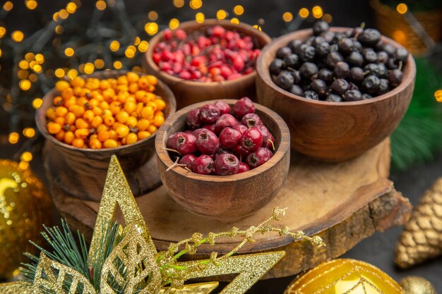 Vorderansicht frische Beeren auf dunklem Hintergrund Fruchtfarbfoto frischer Geschmack wild ausgereift viele Weihnachten