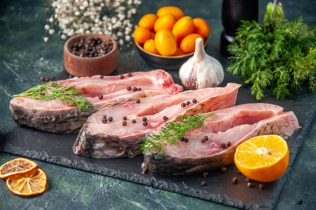 Vorderansicht frische Fischscheiben mit Pfeffer auf dunkler Oberfläche Ozeanfleisch Rohmehl Wasser Foto Farbe Abendessen