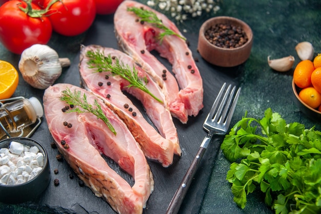 Vorderansicht frische Fischscheiben mit roten Tomaten und Gemüse auf dunkler Oberfläche Meeresfrüchtesalat Mahlzeit Ozean rohes Fleisch Wasser Foto Abendessen Farbe