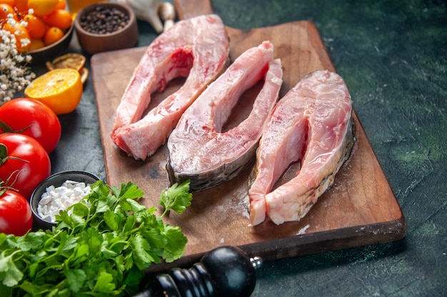 Vorderansicht frische Fischscheiben mit Tomaten und Gemüse auf dunkler Oberfläche Lebensmittel Salat Gesundheit Diät Pfeffer Farbe Mahlzeit