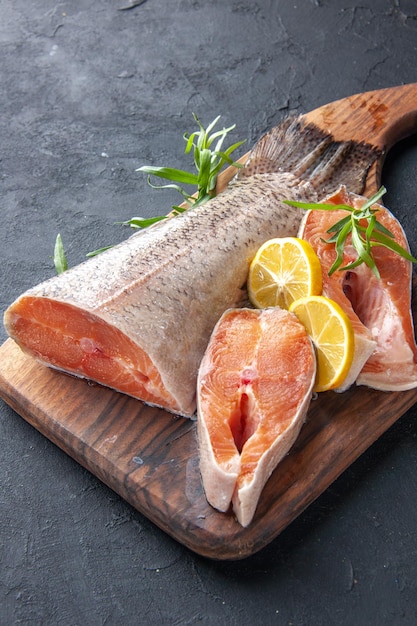 Kostenloses Foto vorderansicht frische fischscheiben mit zitrone auf dunklem hintergrund farbe wasser fleisch lebensmittel meer gesundheit abendessen mahlzeit meeresfrüchte