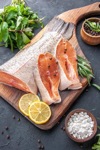 Vorderansicht frische Fischscheiben mit Zitrone und Grün auf dunklem Hintergrund Mahlzeit Meeresfrüchte Gesundheit Fleisch Abendessen Ozean Restaurant Essen