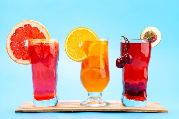 Vorderansicht frische Fruchtcocktails mit frischen Fruchtscheiben Eiskühlung auf blau, Saftsaft Cocktailfruchtfarbe trinken