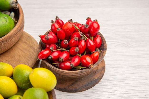 Vorderansicht frische Früchte rote Beeren und Feijoas auf weißem Hintergrund Farbe Beerenobst Foto Gesundheitsdiät