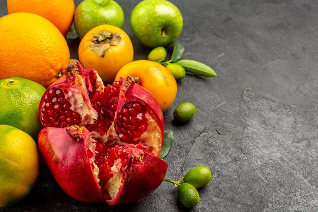 Vorderansicht frische Granatäpfel mit Äpfeln und anderen Früchten auf dunkler Oberfläche reife Fruchtfarbe