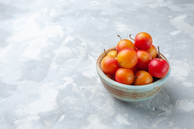 Vorderansicht frische Kirschpflaumen sauer und frisch im Topf auf leichtem Schreibtisch Obst sauer frisch weich