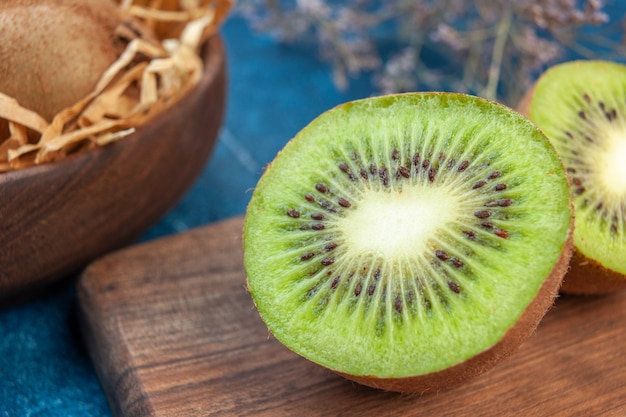 Vorderansicht frische Kiwis auf einer blauen Oberflächenfarbe exotische tropische Fotofrucht gesundes Leben