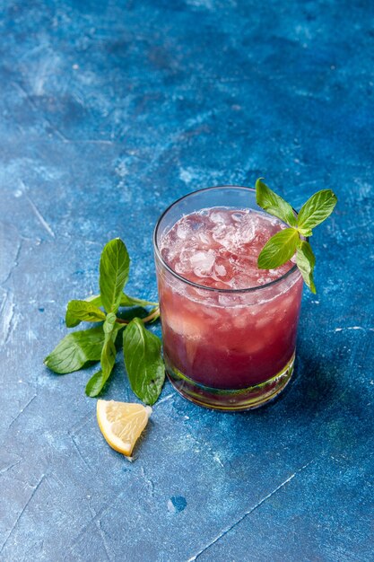 Vorderansicht frische kühle Limonade in kleinem Glas mit Eis auf blauem Hintergrund kaltes Saftgetränk Farbe Wasser Fruchtcocktail