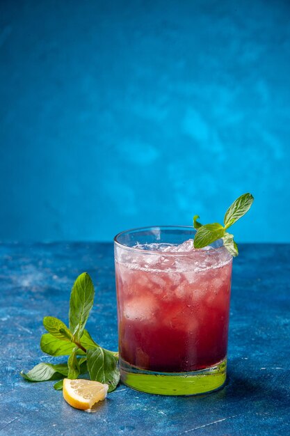 Vorderansicht frische kühle Limonade in kleinem Glas mit Eis auf blauem Hintergrund kaltes Saftgetränk Farbe Wasser Fruchtcocktail