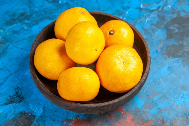Vorderansicht frische Mandarinen im Teller auf dem blauen Tisch