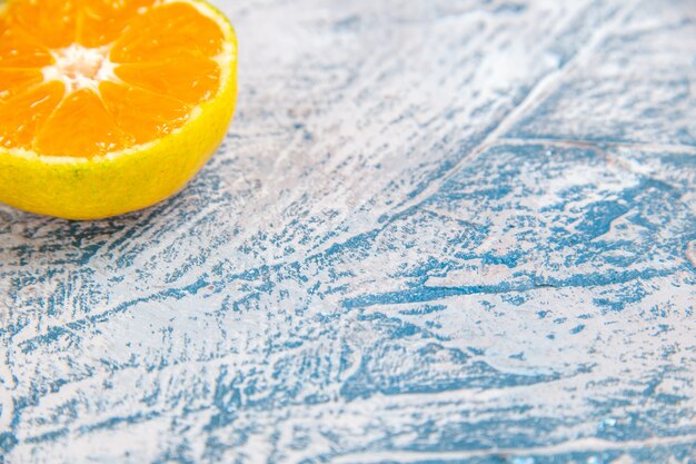 Vorderansicht frische mandarinenscheibe auf hellblauen tischzitrussaftfarbenfrüchten