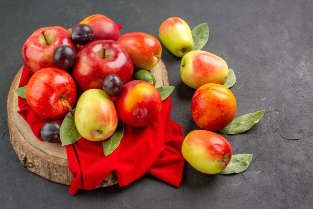 Vorderansicht frische Äpfel und Pflaumen auf dem dunklen Tischsaft reif reif