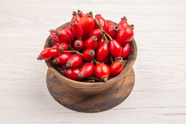 Vorderansicht frische rote Beeren in kleinem Teller auf weißem Hintergrund Gesundheit Beere wilde Farbe Obst Foto