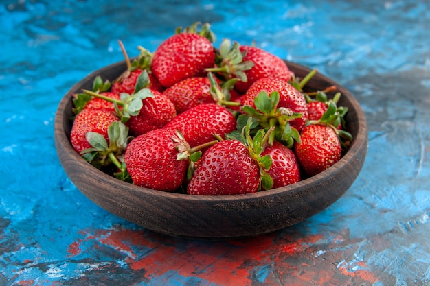 Vorderansicht frische rote Erdbeeren innerhalb der Platte auf blauem Hintergrund Beerenfruchtfarbe Vitamine