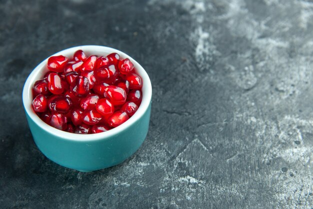 Vorderansicht frische rote Granatäpfel in kleinem Teller auf dunklem Holzschreibtisch Gesundheit Beere wilde Farbe Obst Foto freier Raum