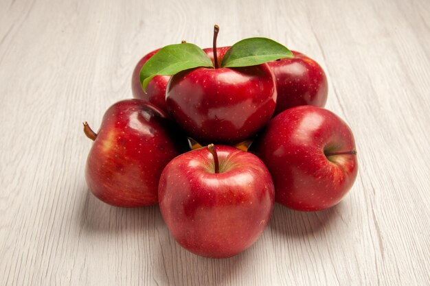 Vorderansicht frische rote Äpfel ausgereifte und reife Früchte auf weißem Schreibtisch Fruchtfarbe frischer Pflanze roter Baum