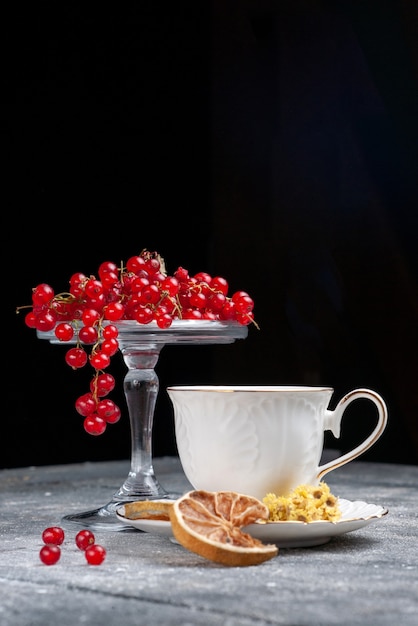 Vorderansicht frische rote preiselbeeren mit tasse kaffee auf dem hellen schreibtisch obstbeere kaffee zitrone
