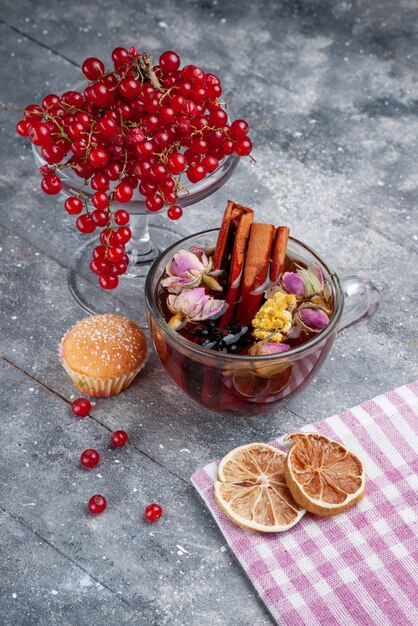 Vorderansicht frische rote Preiselbeeren mit Tasse Tee Zimt auf dem hellen Schreibtisch Obstbeere frische Kaffee Zitrone