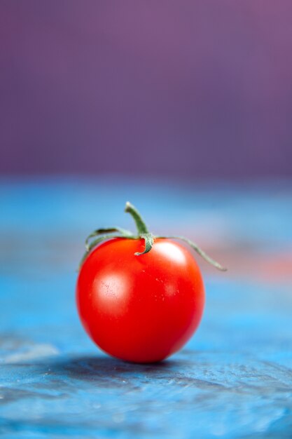 Vorderansicht frische rote Tomate auf dem blau-rosa Tisch