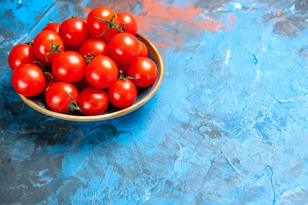 Vorderansicht frische rote Tomaten im Teller auf dem blauen Tisch