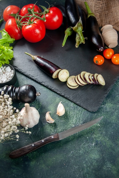 Vorderansicht frische rote Tomaten mit Auberginen auf dunklem Hintergrund