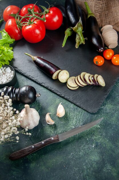 Vorderansicht frische rote Tomaten mit Auberginen auf dunklem Hintergrund