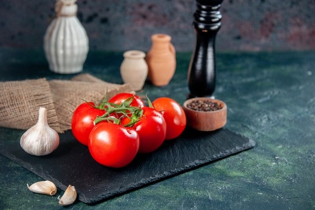 Vorderansicht frische rote Tomaten mit Knoblauch auf dunklem Hintergrund