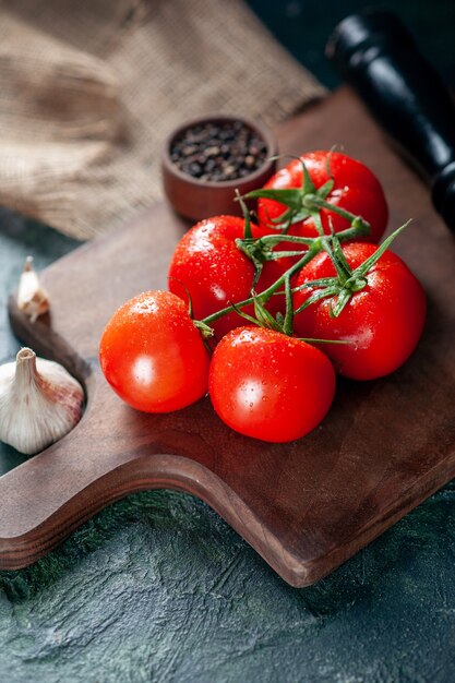 Vorderansicht frische rote Tomaten mit Knoblauch auf dunklem Hintergrund