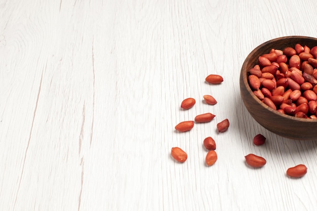 Vorderansicht frische saubere Erdnüsse im Teller auf weißem Schreibtisch Nuss viele Baumpflanzen Shell Snack