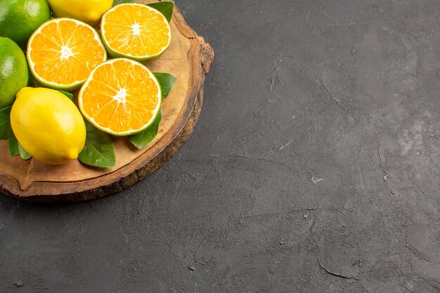 Vorderansicht frische saure Zitronen auf dunklem Boden Baum Limettenfrucht Zitrusfrüchte